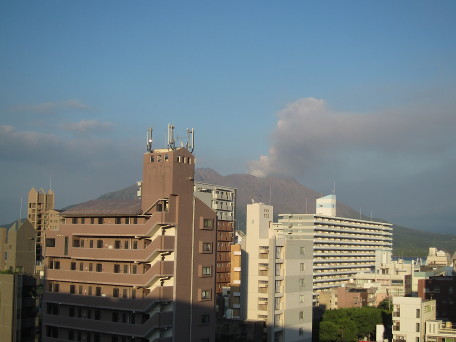 volcanic cloud from Sakurajima, seen over city buildings