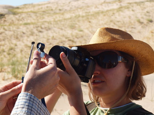 A person taking a picture of mangetic sand grains
