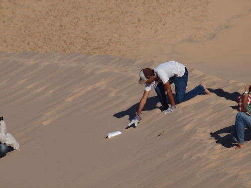 Dry ice block sliding down sand dune